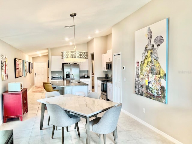 tiled dining room with lofted ceiling and sink