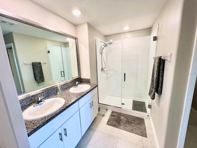 bathroom with tile patterned floors, a shower with door, and vanity