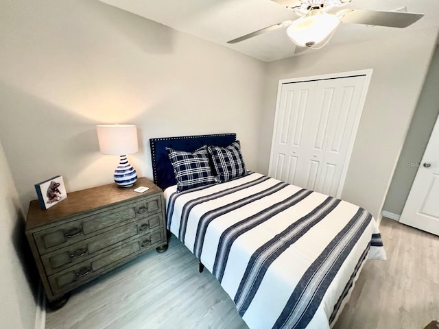 bedroom featuring ceiling fan, light wood-type flooring, and a closet