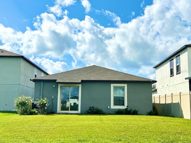 rear view of house featuring a lawn