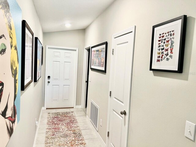 corridor featuring light tile patterned flooring and lofted ceiling