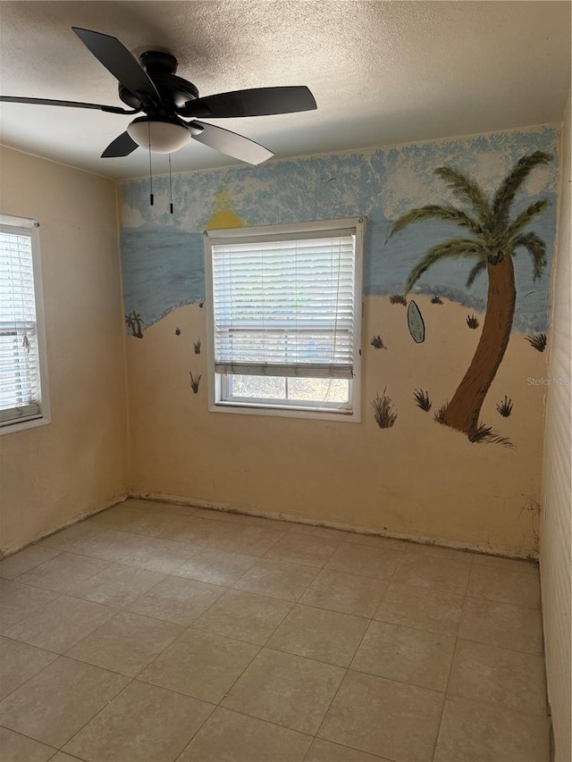 empty room with a textured ceiling and ceiling fan