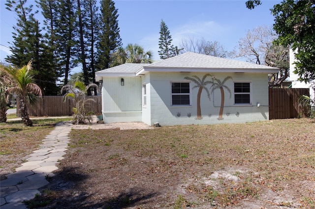 view of front of property featuring roof with shingles and fence