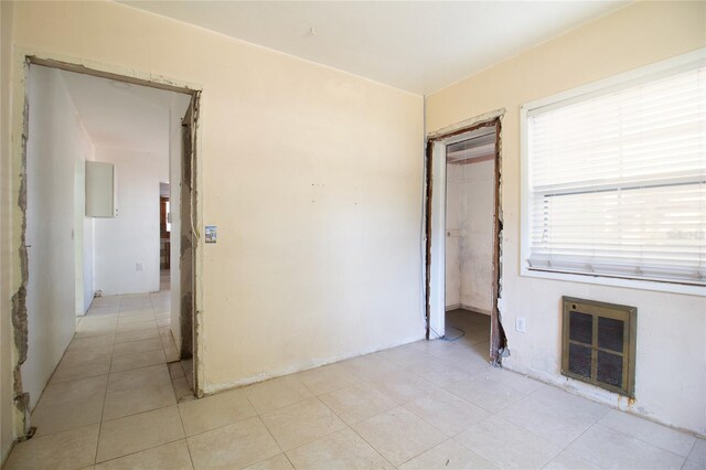 interior space with light tile patterned flooring and heating unit