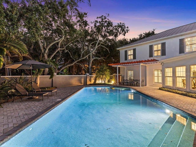 pool at dusk with a patio