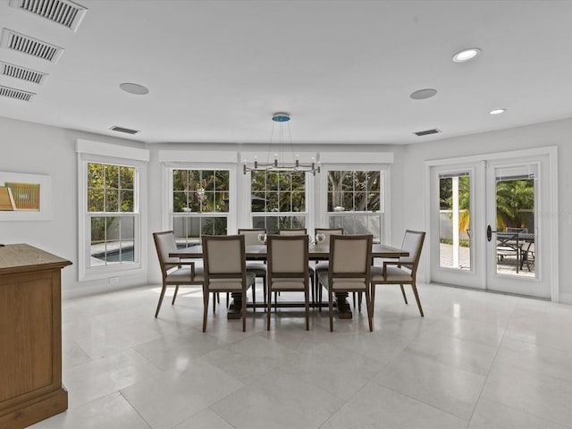 dining area featuring light tile patterned flooring, french doors, and an inviting chandelier