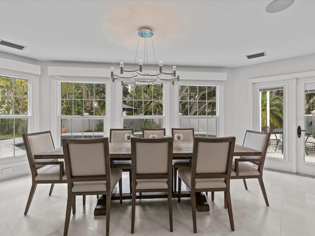 dining room featuring light tile patterned flooring and a chandelier