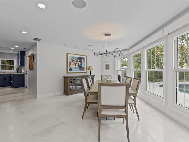 dining space featuring light tile patterned floors and an inviting chandelier