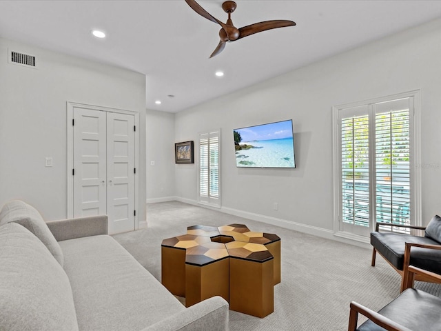 carpeted living room with ceiling fan and a healthy amount of sunlight