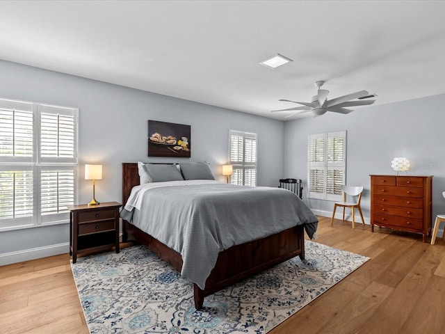 bedroom featuring light hardwood / wood-style flooring, multiple windows, and ceiling fan