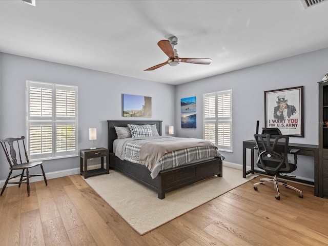 bedroom with wood-type flooring, multiple windows, and ceiling fan