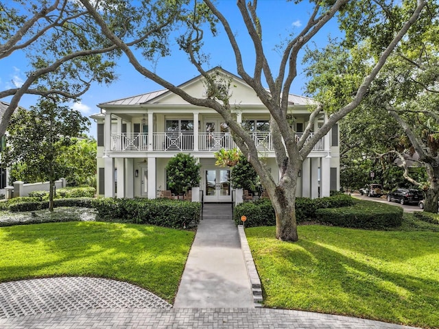 neoclassical / greek revival house with a front lawn, a porch, french doors, and a balcony