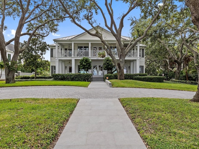 view of front facade featuring a balcony and a front lawn