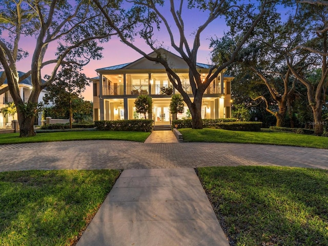 view of front of home featuring a balcony and a lawn