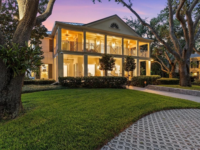 view of front of property with a balcony and a lawn