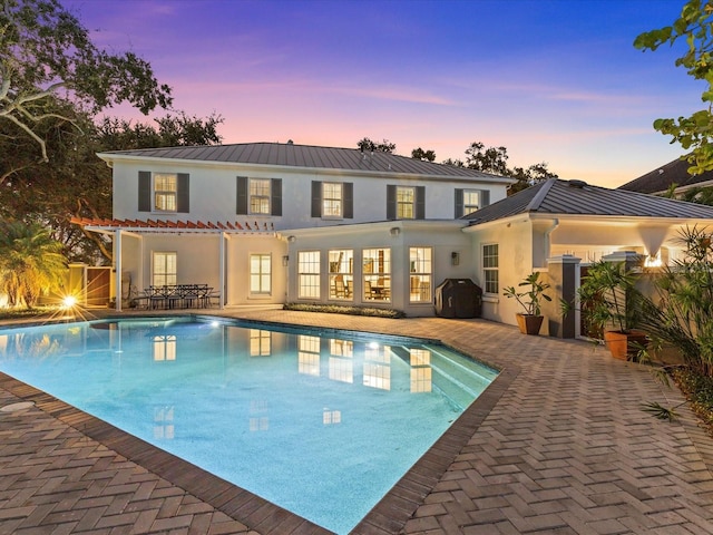 pool at dusk featuring area for grilling and a patio area