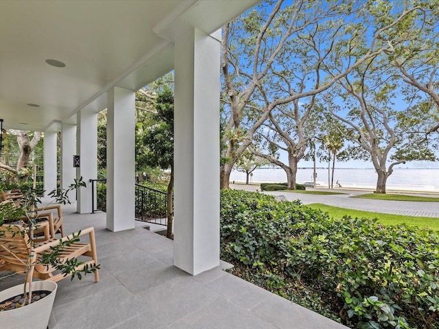 view of patio featuring a water view and covered porch