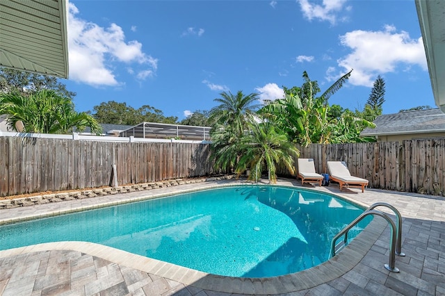 view of pool with glass enclosure and a patio