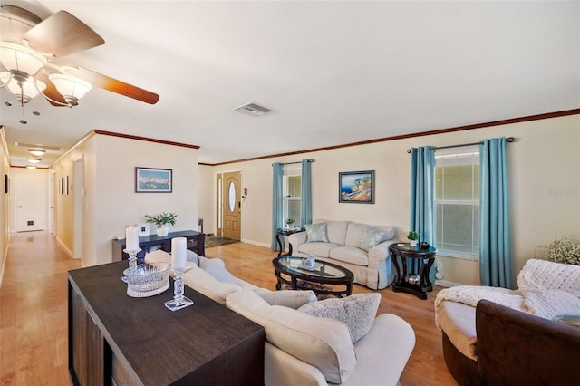 living room with light hardwood / wood-style floors, ceiling fan, and crown molding