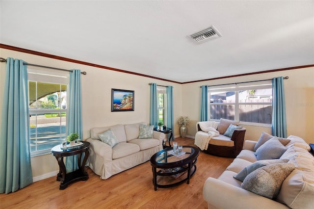 living room with light hardwood / wood-style floors and crown molding