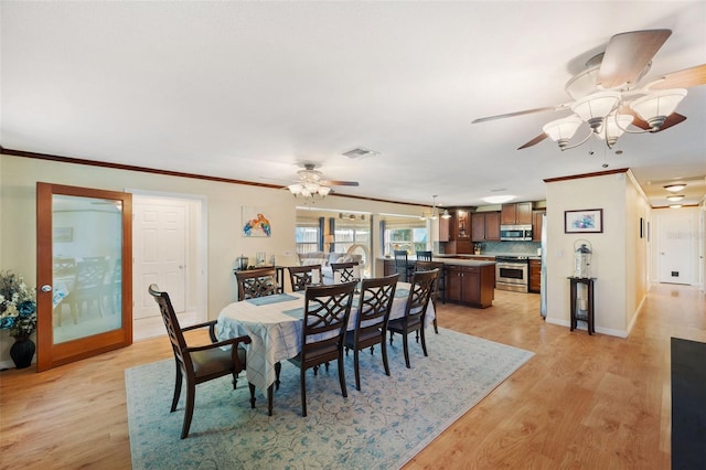 dining area with ceiling fan, crown molding, and light hardwood / wood-style floors