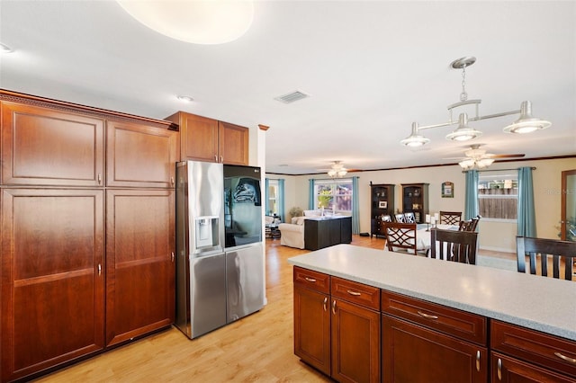 kitchen featuring ceiling fan, pendant lighting, stainless steel refrigerator with ice dispenser, and light hardwood / wood-style floors