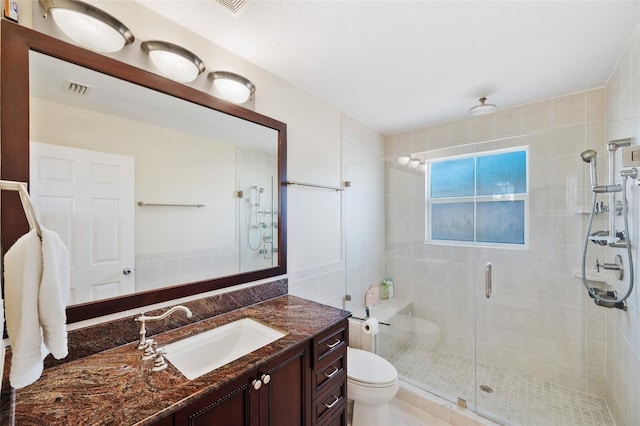 bathroom featuring walk in shower, vanity, toilet, and tile patterned floors