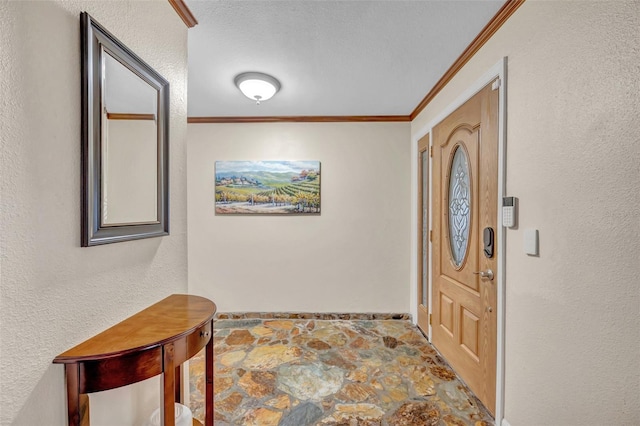 foyer featuring a textured wall, stone finish flooring, and crown molding