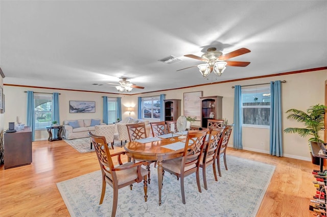 dining area featuring light wood-style floors, visible vents, a ceiling fan, and ornamental molding