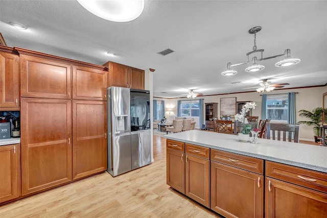 kitchen with light countertops, brown cabinetry, and ceiling fan