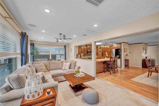 living room featuring light wood finished floors, baseboards, visible vents, and recessed lighting