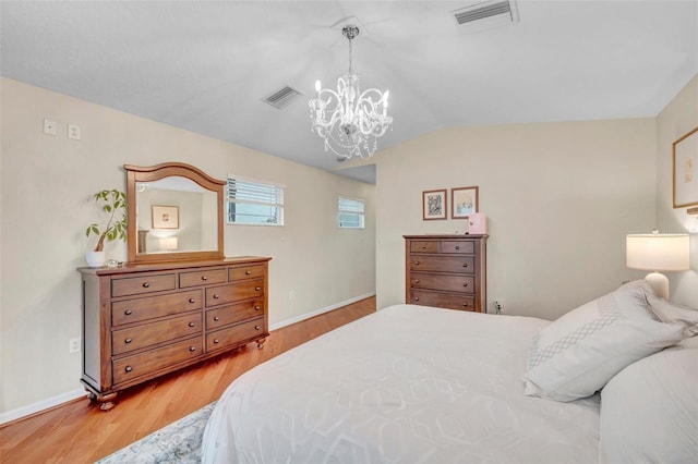 bedroom featuring light wood-style flooring, visible vents, and a notable chandelier