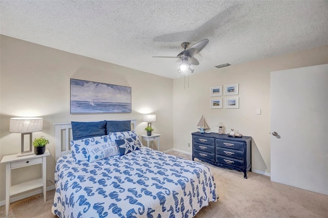 bedroom featuring light carpet, a ceiling fan, a textured ceiling, and visible vents