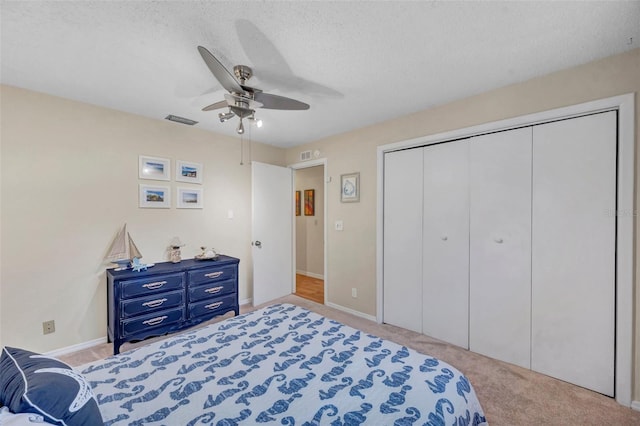 bedroom with a closet, carpet, visible vents, and ceiling fan