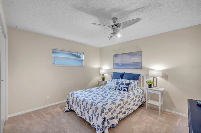 bedroom featuring ceiling fan, baseboards, a textured ceiling, and carpet