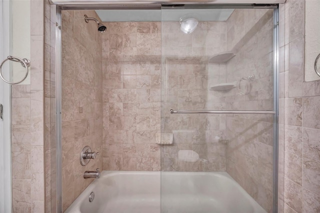bathroom with bath / shower combo with glass door
