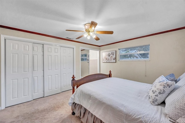bedroom with a ceiling fan, crown molding, a closet, carpet floors, and visible vents