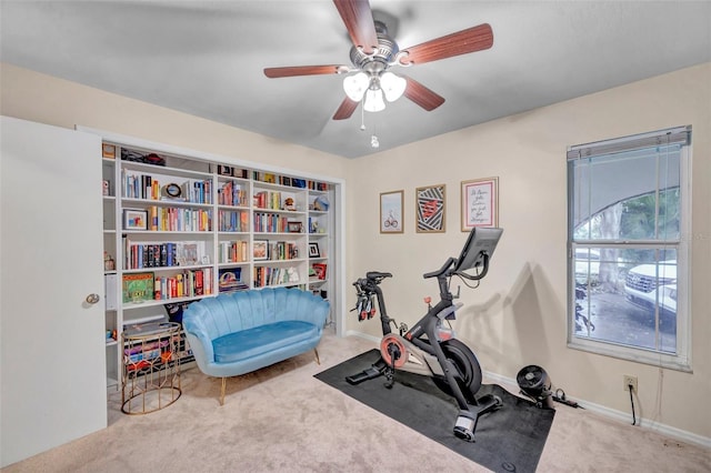exercise room with carpet flooring, baseboards, and a ceiling fan