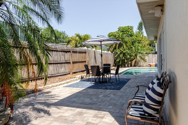 view of patio / terrace featuring a fenced backyard, outdoor dining space, and a fenced in pool