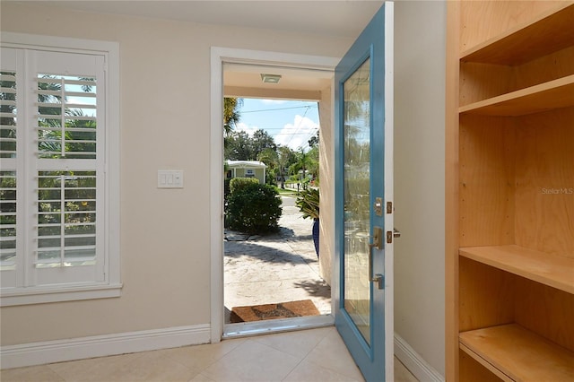 doorway to outside with a healthy amount of sunlight and light tile patterned flooring