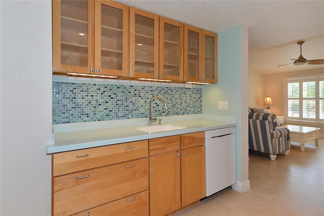 kitchen featuring tasteful backsplash, sink, dishwasher, a textured ceiling, and ceiling fan