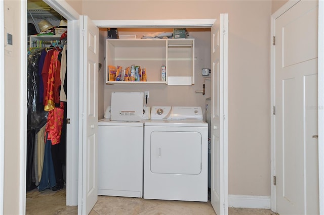 clothes washing area featuring light tile patterned flooring and washer and clothes dryer