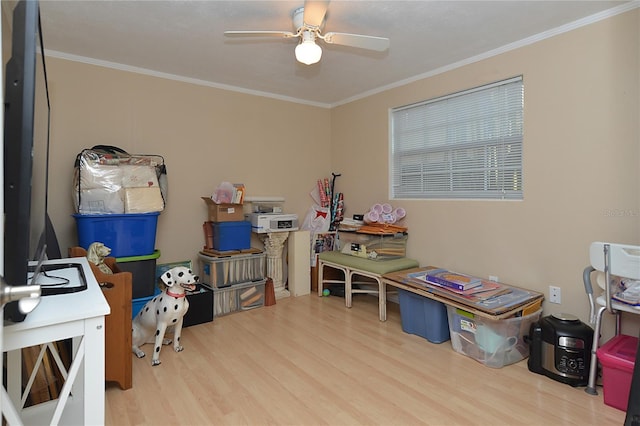 playroom featuring crown molding, wood-type flooring, and ceiling fan