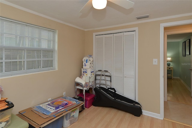 recreation room with crown molding, hardwood / wood-style flooring, and ceiling fan