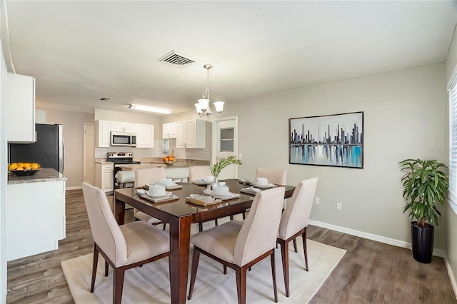 dining room featuring dark wood-type flooring and a notable chandelier