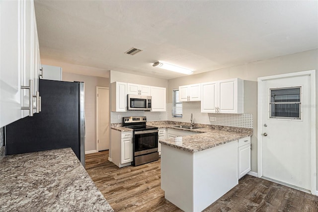 kitchen with white cabinets, appliances with stainless steel finishes, dark wood-type flooring, and sink