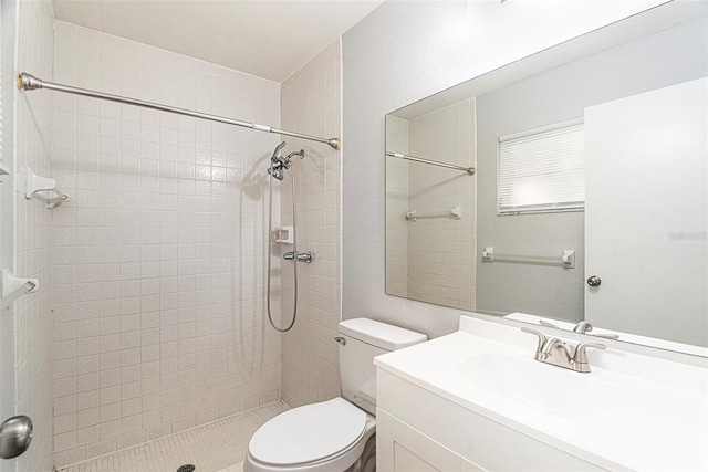 bathroom featuring toilet, vanity, and a tile shower