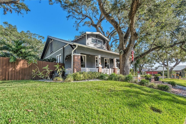 view of front of house with covered porch and a front lawn