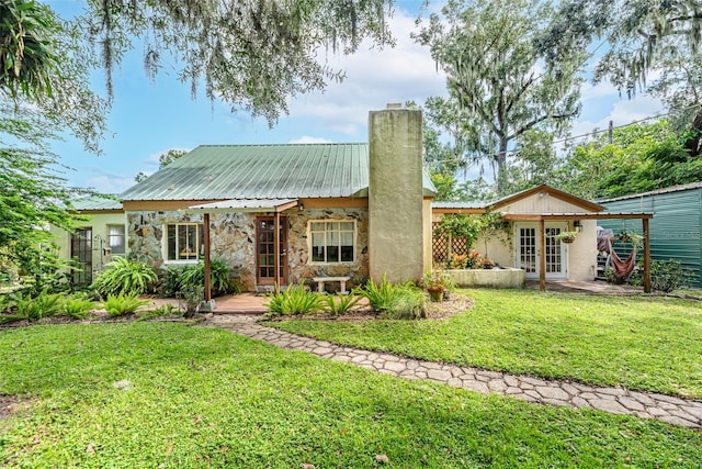 rear view of property featuring a yard and french doors