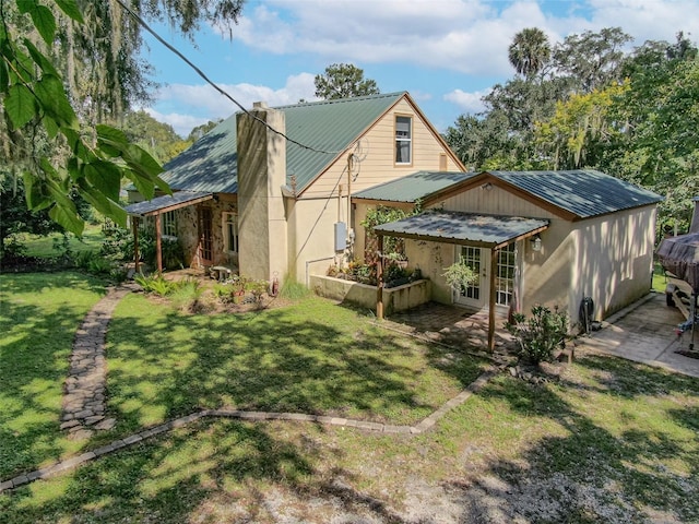 rear view of house featuring a lawn and a patio